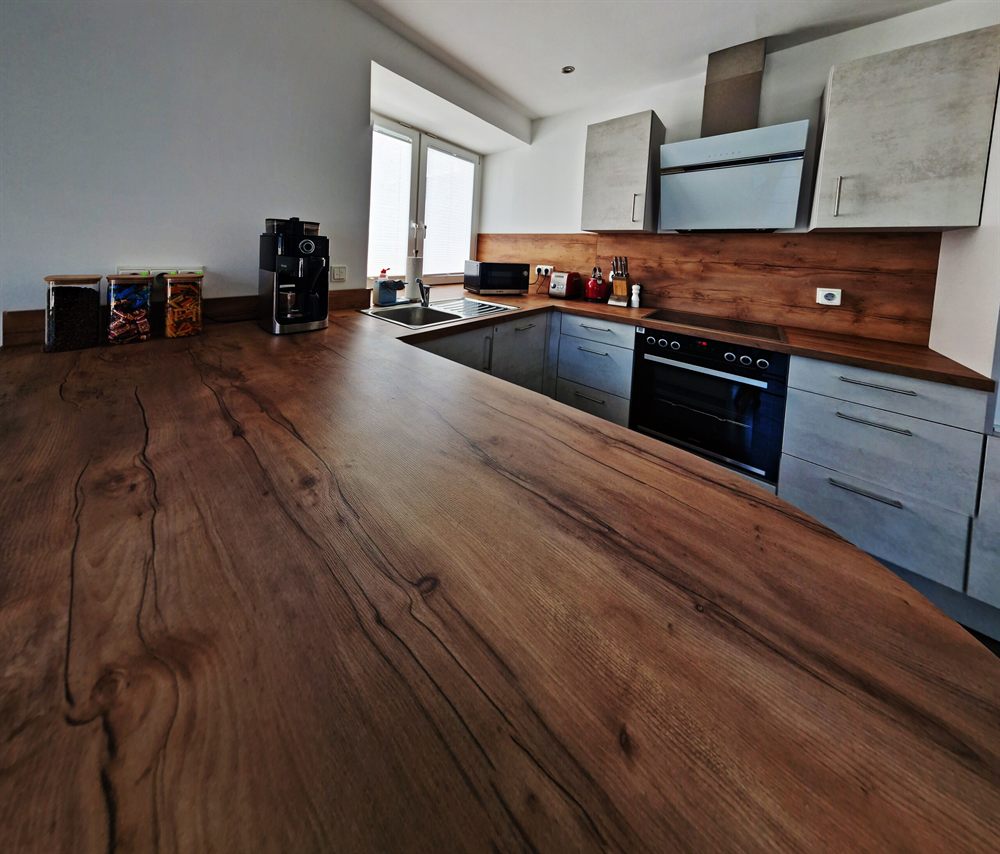 Große Küche der Wohnung mit Backofen, Kochfeld, Spüle und Kaffeemaschine