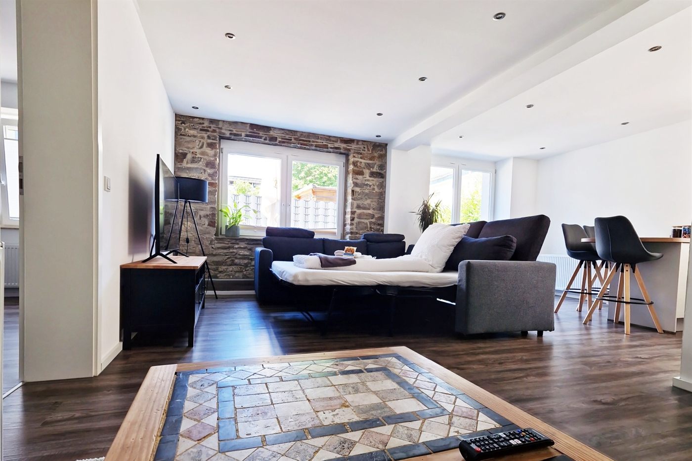 Ausgeklappte und bezogene Schlafcouch im Wohnzimmer