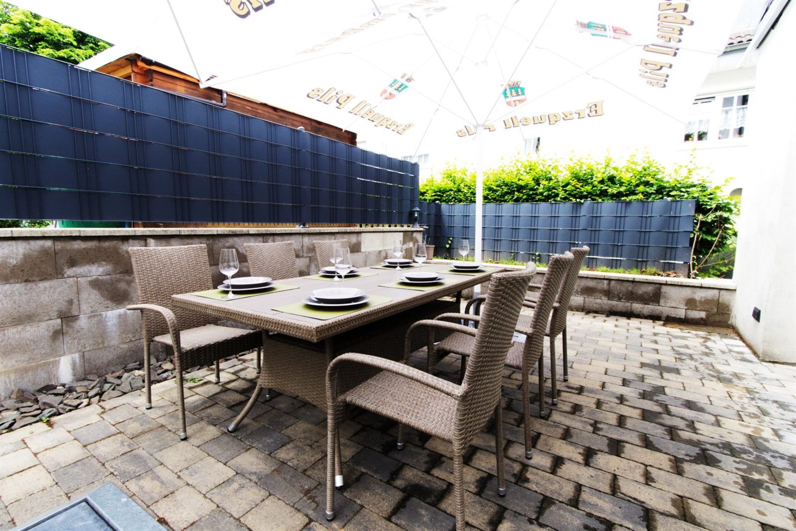 Terrasse mit großem Esstisch und Sichtschutz