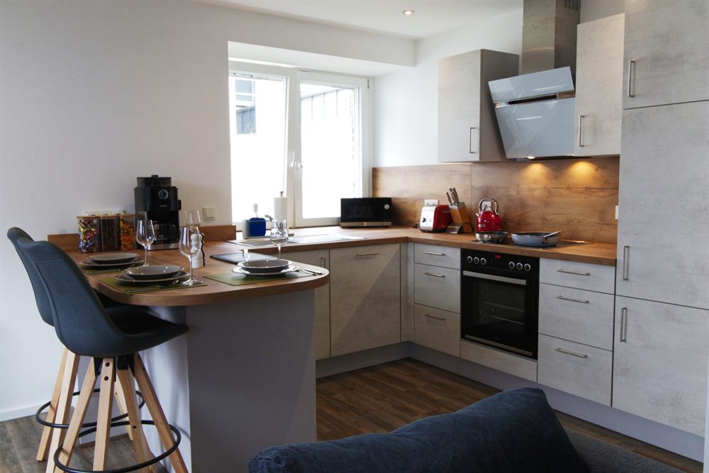 Offene Küche mit Theke, Barhockern und Kaffeemaschine